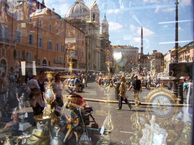 La Piazza Navona vista en la vitrina de un anticuario.

Piazza Navona seen through the window shop of an antique store.